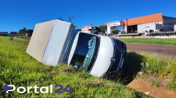 Caminhão carregado com perfumaria tomba após cair em canaleta de rodovia; ninguém se feriu