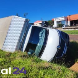 Caminhão carregado com perfumaria tomba após cair em canaleta de rodovia; ninguém se feriu
